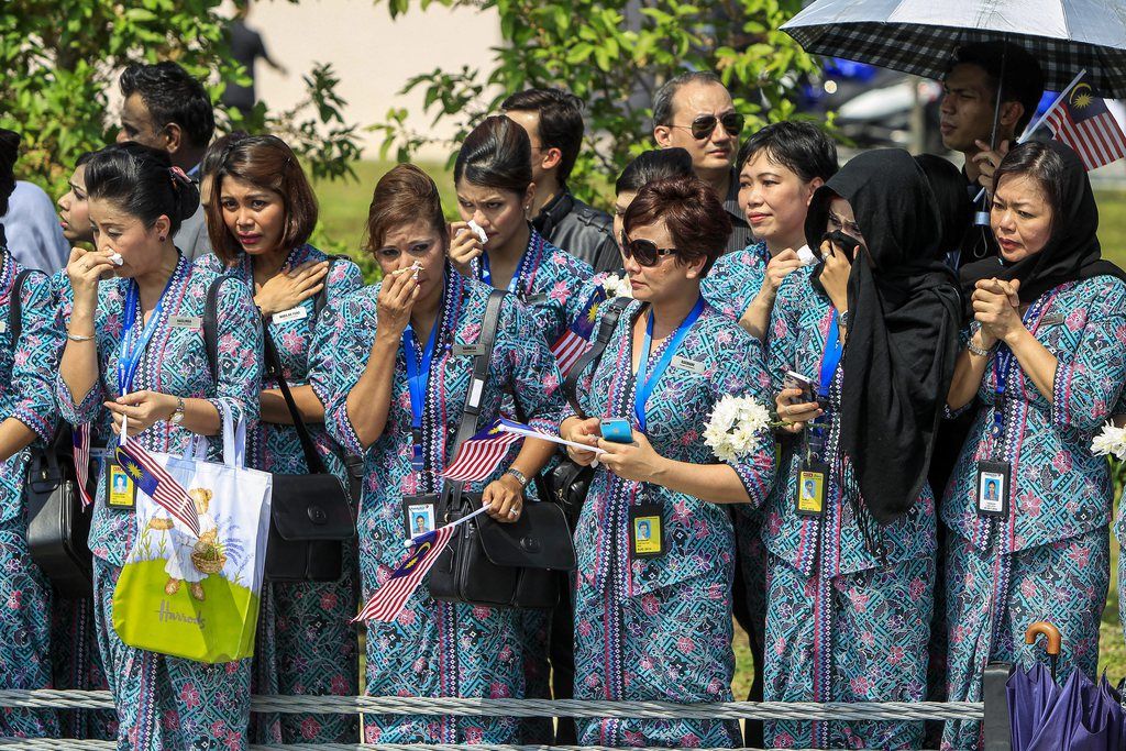 epa04363348 Malaysia Airlines crew members wait for the convoy of hearses during the ceremony of MH17 victims arrival home at the Kuala Lumpur International airport in Sepang, Malaysia, 22 August 2014. About 20 remains of the victims of the MH17 plane crash arrived in Kuala Lumpur on a special flight from the Netherlands as Malaysia declared 22 August as national mourning day. 298 people died when the Malaysia Airlines flight MH17 was presumably shot down over Ukraine on July 17.  EPA/AZHAR RAHIM