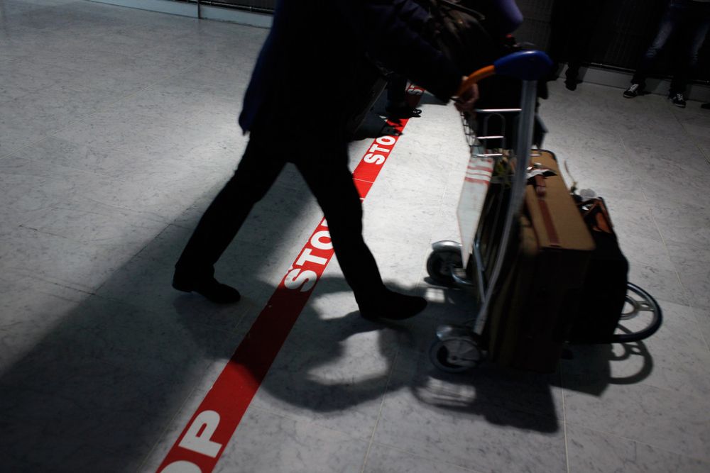 A passenger crosses a stop line as he arrives at Roissy Charles de Gaulle airport, in Roissy, north of Paris, Saturday, Oct. 18, 2014. France will begin screening airline passengers for Ebola in coming days at Paris' Charles de Gaulle airport. The Paris airport authority says that medical teams will take passengers' temperatures before they leave the air bridge to enter the terminal. (AP Photo/Thibault Camus)