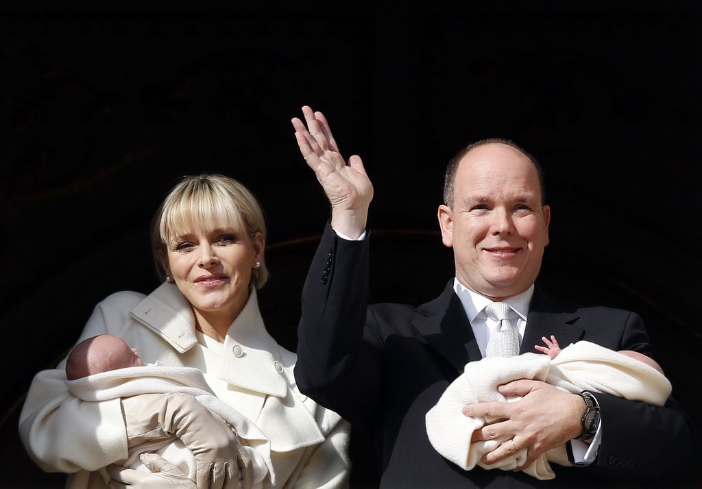 Princess Charlene and Prince Albert appear on a palace balcony, each holding a newborn baby swaddled in white in Monaco, Wednesday, Jan. 7, 2015. The hereditary heir Prince Jacques and his older sister ? by 2 minutes ? Gabriella were greeted by a small sea of red-and-white flags and banners.  (AP Photo/Sebastien Nogier, Pool)