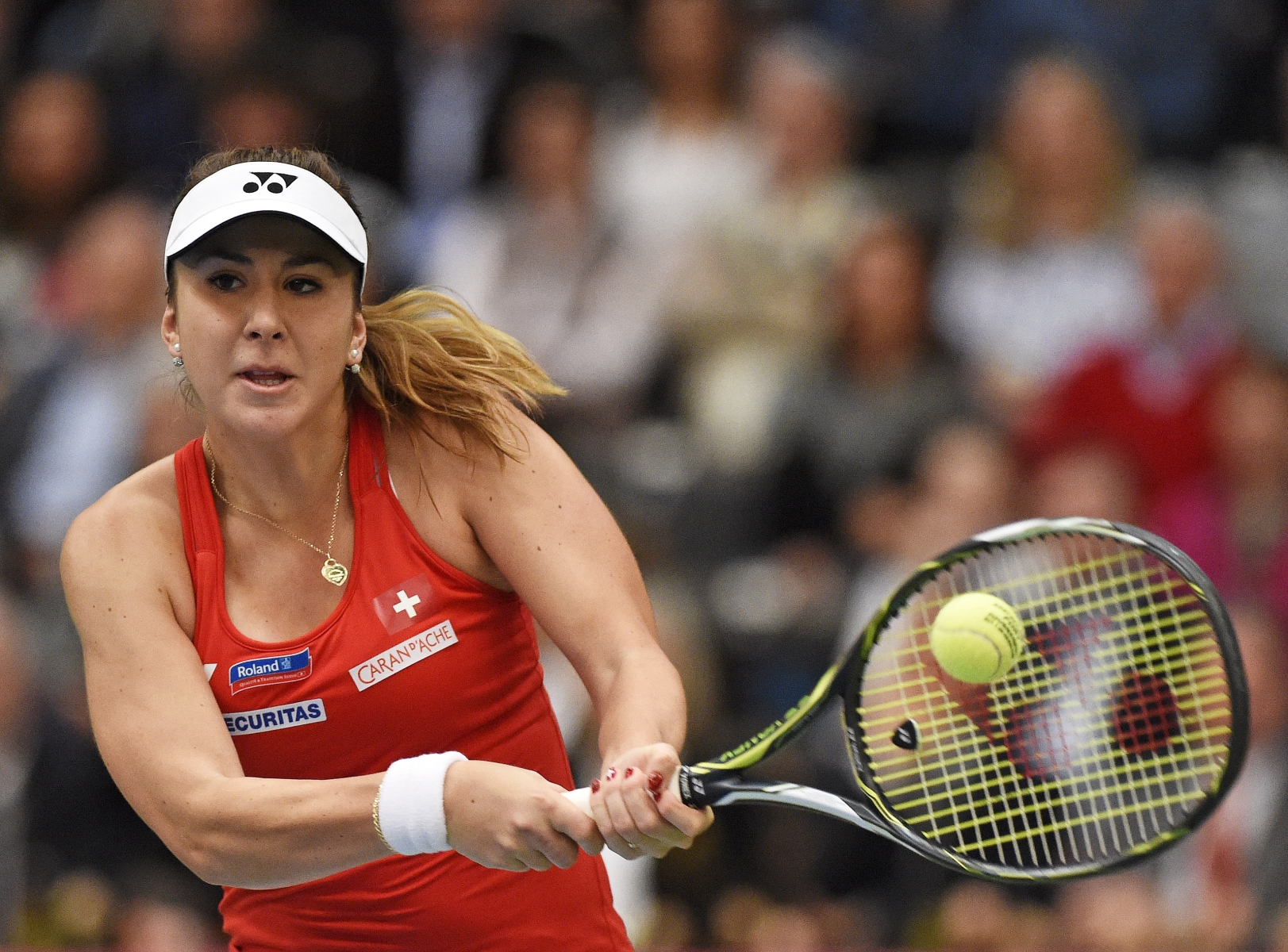 FILE - In this Feb. 7, 2016 file picture Belinda Bencic of Switzerland returns a ball to Angelique Kerber of  Germany during their Fed Cup World Group first round tennis match between Germany and Switzerland  in Leipzig, Germany. Switzerland's No. 1 Belinda Bencic has withdrawn due to a back injury from a Fed Cup semifinal against defending champion Czech Republic next weekend.  The Swiss tennis federation says  Sunday April 10, 2016 the 10th-ranked Bencic must rest for at least four weeks. Switzerland hosts the Czechs next Saturday and Sunday on indoor hard courts at Lucerne.   (AP Photo/Jens Meyer)
