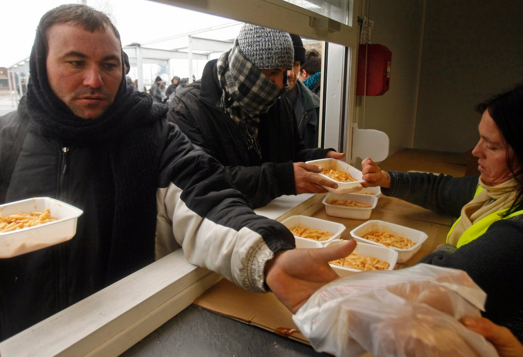 Immigrants get food from a charity organization in Calais, northern France, Monday, Feb. 8, 2010.  On Sunday officers moved some 100 illegal immigrants and about 20 activists from a hangar in the English Channel port city of Calais. Immigrants coming from as far away as Afghanistan and Iran gather in Calais trying to make their way to Britain. (KEYSTONE/AP Photo/Michel Spingler) FRANCE IMMIGRANTS