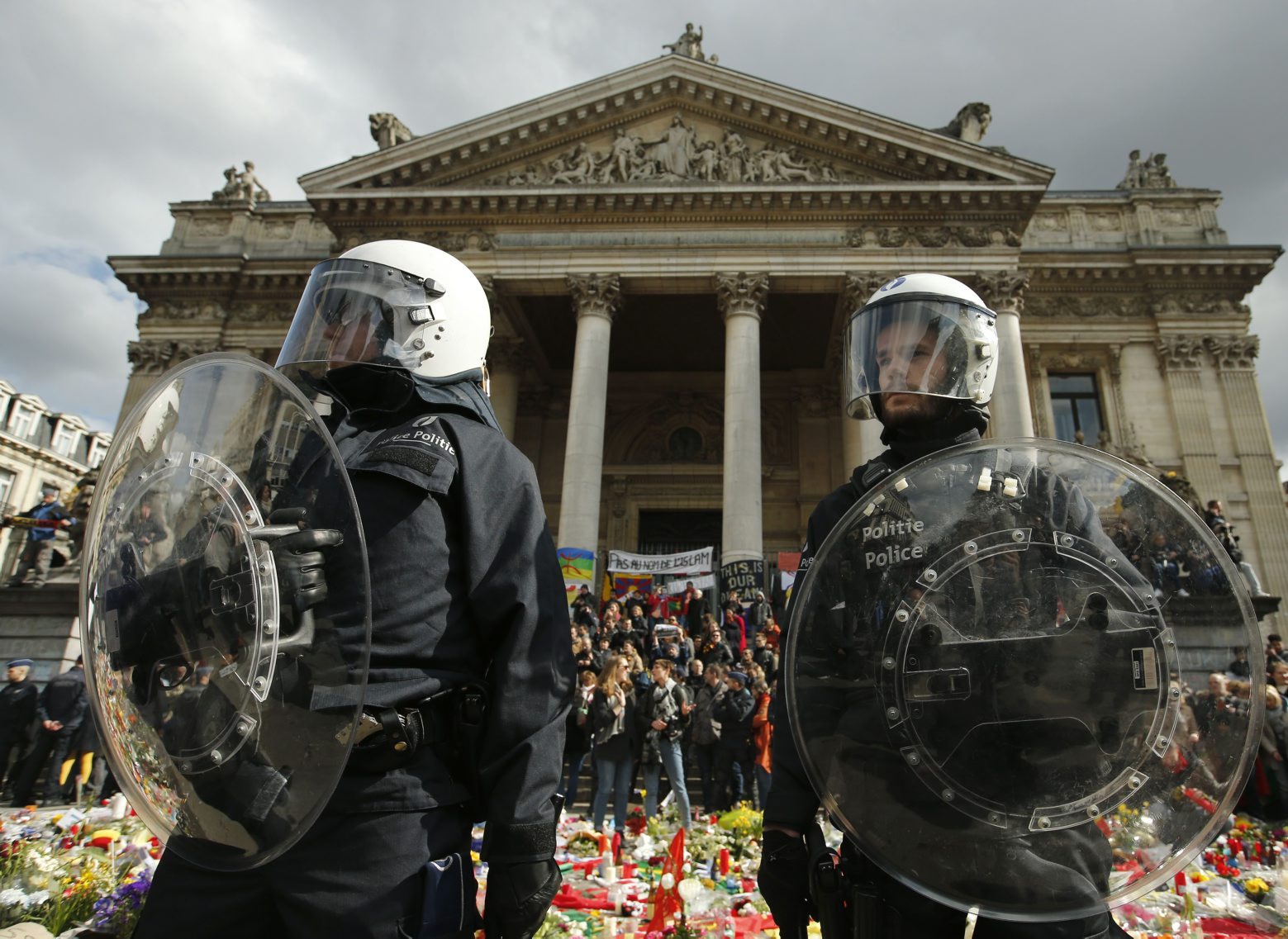 Police in riot gear protect one of the memorials to the victims of the recent Brussels attacks, as right wing demonstrators protest near the Place de la Bourse in Brussels, Sunday, March, 27, 2016. In a sign of the tensions in the Belgian capital and the way security services are stretched across the country, Belgium's interior minister appealed to residents not to march Sunday in Brussels in solidarity with the victims."We understand fully the emotions," Interior Minister Jan Jambon told reporters. "We understand that everyone wants to express these feelings."(AP Photo/Alastair Grant) BELGIUM ATTACKS