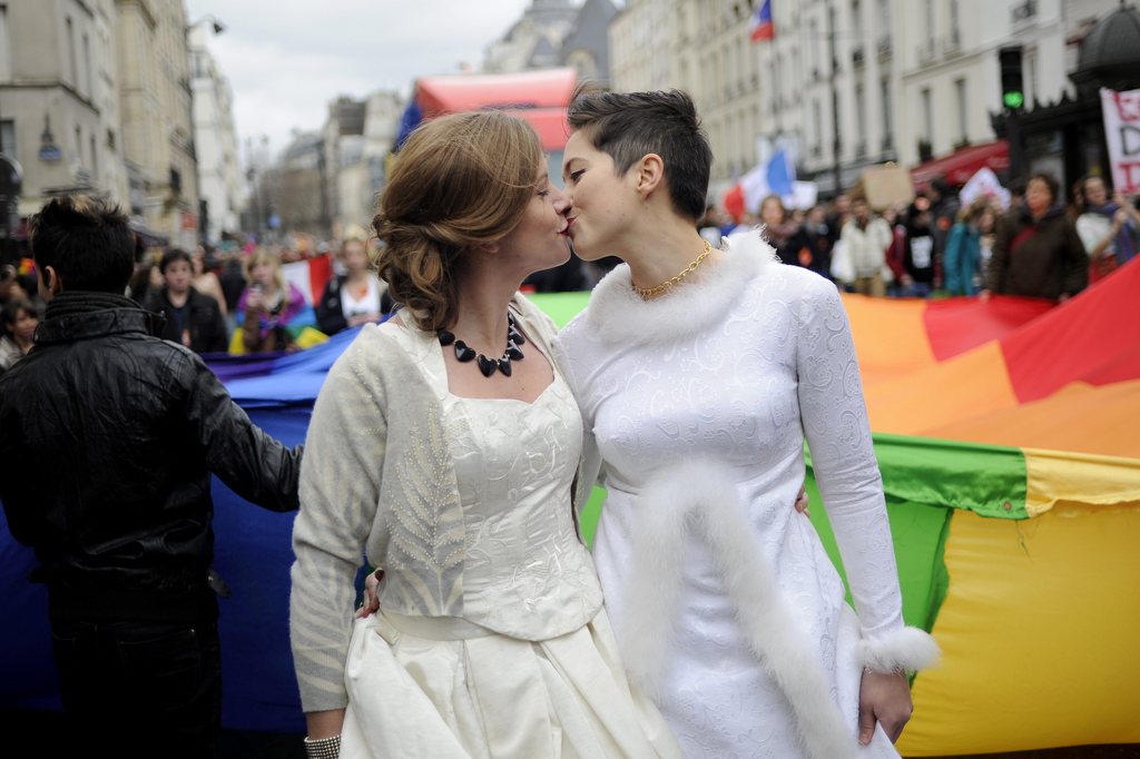 epa03511242 A female couple share a kiss during a demonstration in favour of legalizing gay marriage in Paris, France, 16 December 2012. According to media reports, tens of thousands of people demonstrated 16 December in France in favour of gay marriage, a week after more than 100,000 took to the streets to oppose government moves in that direction.  EPA/YOAN VALAT