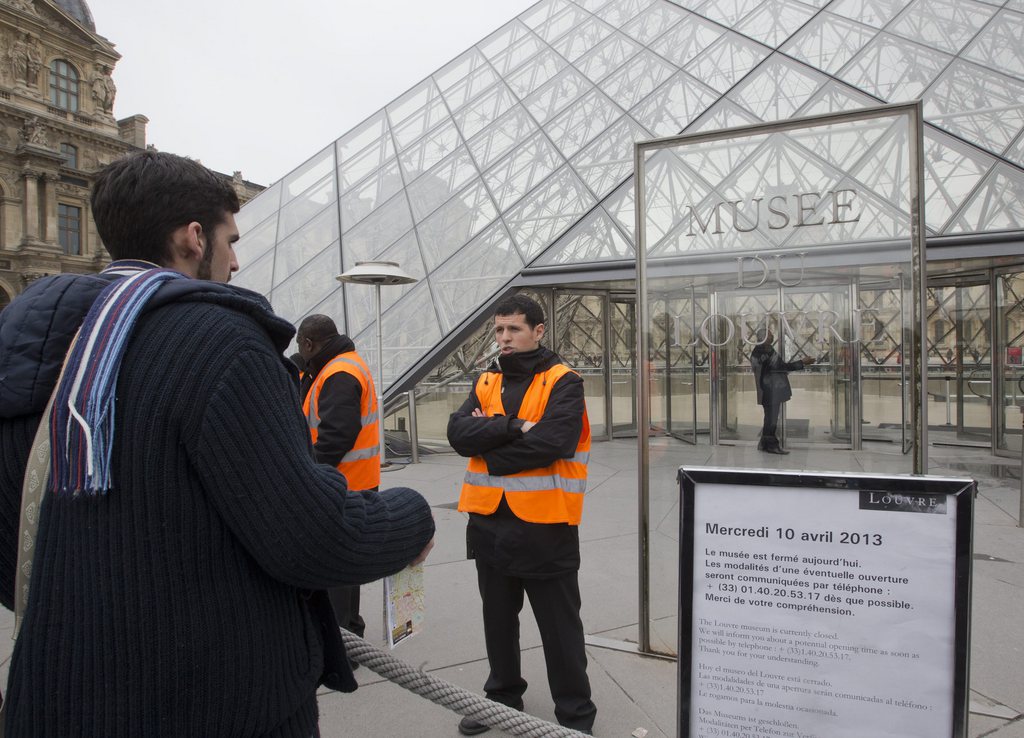 A visitor stands in front of to entrance in Louvre museum Paris, France, Wednesday, April 10, 2013. Paris' famed Louvre museum has been closed after workers walked off the job to protest what they say is the increasing problem of pickpockets at work in the museum's vast galleries. Louvre spokeswoman Sophie Grange said the museum, which normally attracts up to 30,000 visitors a day at this time of year, did not open Wednesday. She was unable to say when the museum would reopen or provide a figure for the number of pickpocketing victims at the museum. (AP Photo/Jacques Brinon)