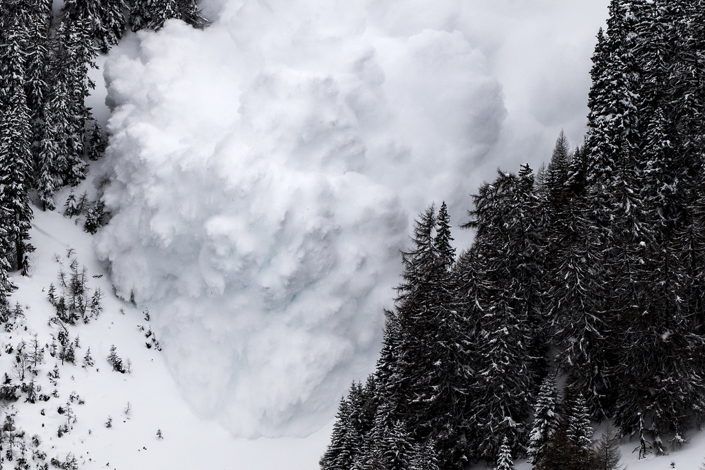 An avalanche comes down during an artificially avalanche explosion which is conducted for test purposes by the avalanche researchers of the WSL Institute for Snow and Avalanche Research SLF at the Vallee de la Sionne test site, in Anzere, near Sion, in the Canton of Valais, Switzerland, Wednesday, March 8, 2017. (KEYSTONE/Jean-Christophe Bott)