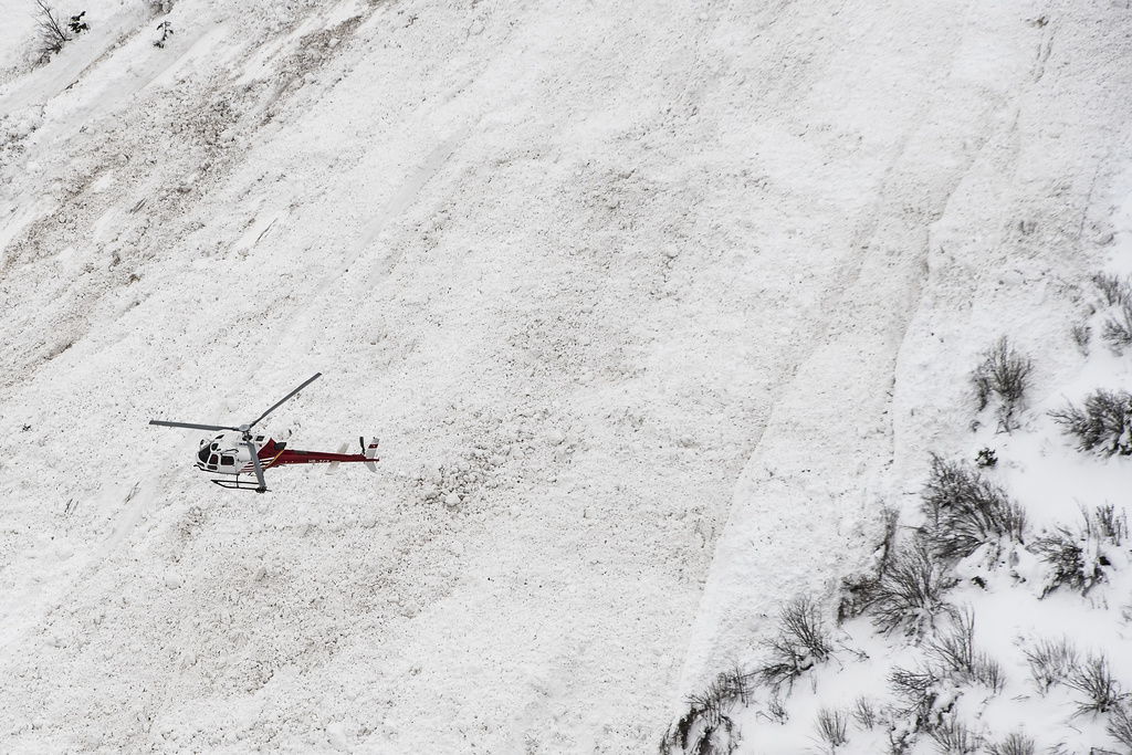 An helicopter surveys the site where an avalanche was artificially triggered for test purposes by the avalanche researchers of the WSL Institute for Snow and Avalanche Research SLF at the Vallee de la Sionne test site, in Anzere, near Sion, in the Canton of Valais, Switzerland, Wednesday, March 8, 2017. (KEYSTONE/Jean-Christophe Bott)
