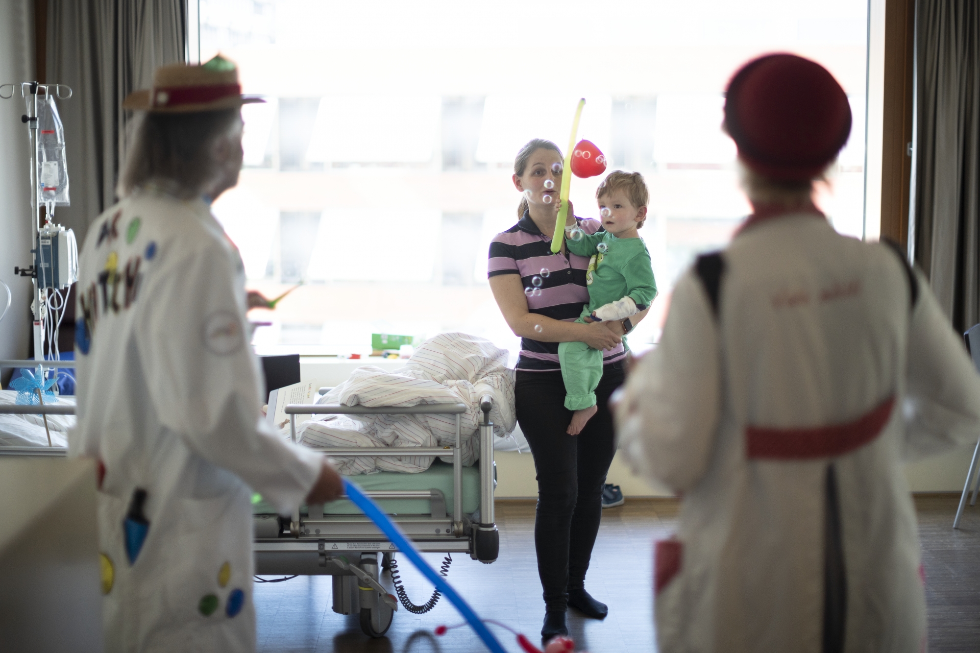 Hospital clowns of the Theodora Foundation, also referred to as dream doctors, visit a hospitalized child at the University Children's Hospital Basel (UKBB) in Basel, Switzerland, on March 28, 2019. The dream doctors of the Theodora Foundation visit children in hospitals, hospices and specialist care centres. (KEYSTONE/Gaetan Bally)