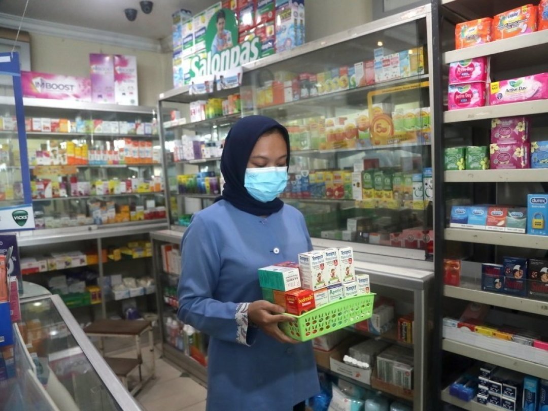 Une pharmacienne retire des sirops pour enfants des rayons de son commerce de la ville de Depok, dans la province de Java occidental.