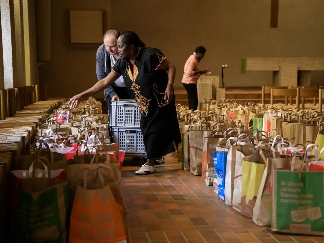 Des bénévoles remplissent des sacs avec des denrées alimentaires provenant de La Centrale alimentaire de la région lausannoise pour une distribution depuis l'église Saint-Jacques le mercredi 19 octobre 2022 à Lausanne.