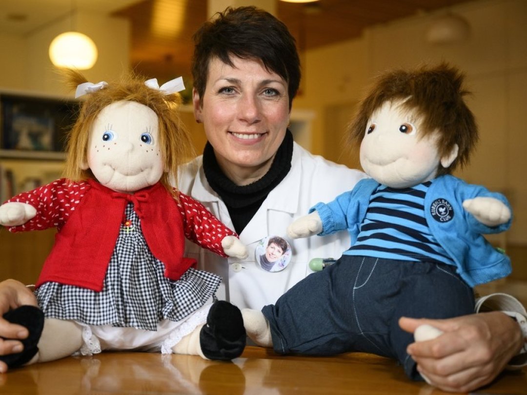Patrizia D'Amelio, médecin cheffe au Service de gériatrie du CHUV, pose avec deux poupées thérapeutiques utilisées pour traiter des démences.