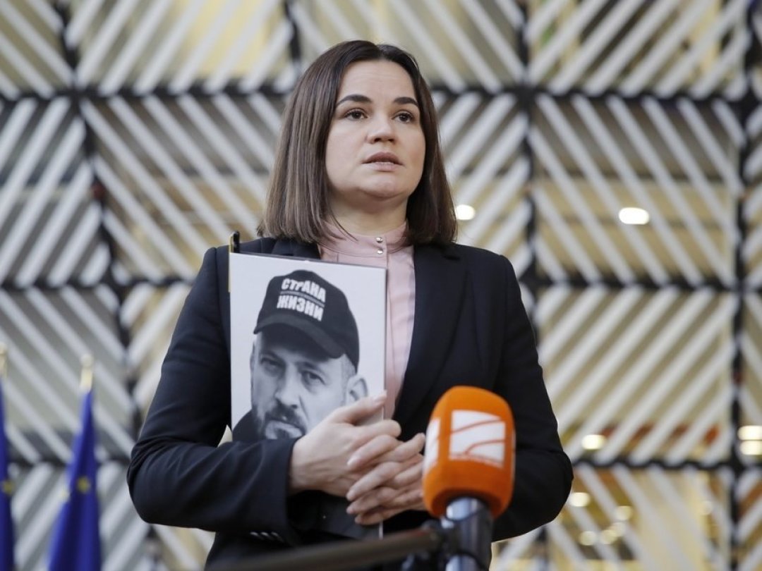 Svetlana Tikhanovskaïa tient un portrait de son mari, le blogueur Sergueï Tikhanovski, lors d'une conférence de presse à Bruxelles, le 14 novembre 2022.