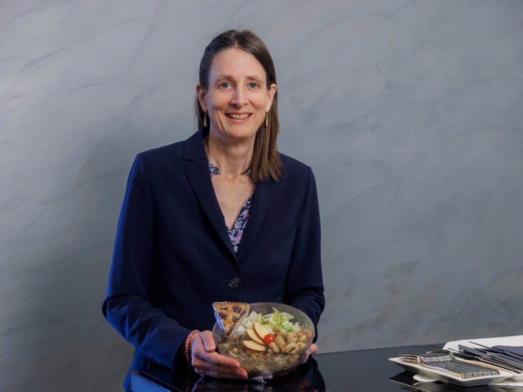 Céline Weber dans le restaurant du Palais fédéral tenant la salade du jour cuisinée exclusivement avec des invendus alimentaires.