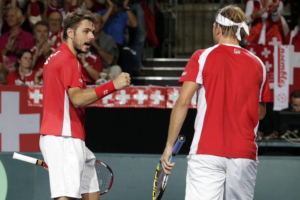 Switzerland's Stanislas Wawrinka, left, and his doubles partner, Michael Lammer, right, react after wining a point against the Ecuador's Emilio Gomez and Roberto Quiroz, during their Davis Cup World Group Play-off round doubles match between Switzerland and Ecuador, in Neuchatel, Switzerland, Saturday, September 14, 2013. (KEYSTONE/Salvatore Di Nolfi)