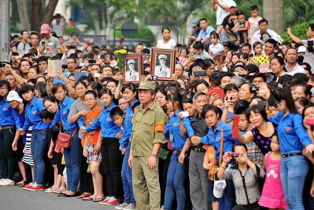 epa03908149 People gather waiting to see the coffin of late General Vo Nguyen Giap passing by in a street in Hanoi, Vietnam, 13 October 2013. General Vo Nguyen Giap, a key figure in securing Vietnam's independence and winning the Vietnam War, died on 04 October 2013 at the age of 102, senior military officials and a relative said. The general had been in hospital for several years because of ill health. The national funeral of late General Vo Nguyen Giap was held on 12 and 13 October 2013.  EPA/STRINGER