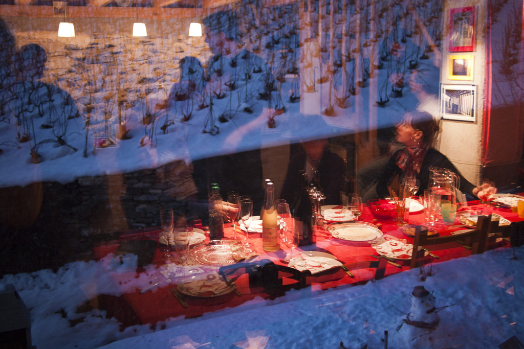 Die Familie nimmt den Apero ein, gesehen als Reflex in der Fensterscheibe, waehrend einer privaten Weihnachtsfeier, in Flanthey VS, am Weihnachtstag, 25. Dezember 2011. (KEYSTONE/Alessandro della Valle)