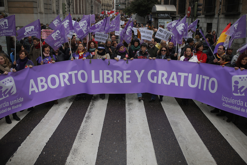 Protestors carry a banner reading, "Abortion: free and for free" as they march during a protest against Spanish government's plan to implement major restrictions on abortion in Madrid, Spain, Saturday, Feb. 8, 2014. The rally was organized Saturday by dozens of women's groups that fight for reproductive rights. (AP Photo/Andres Kudacki)