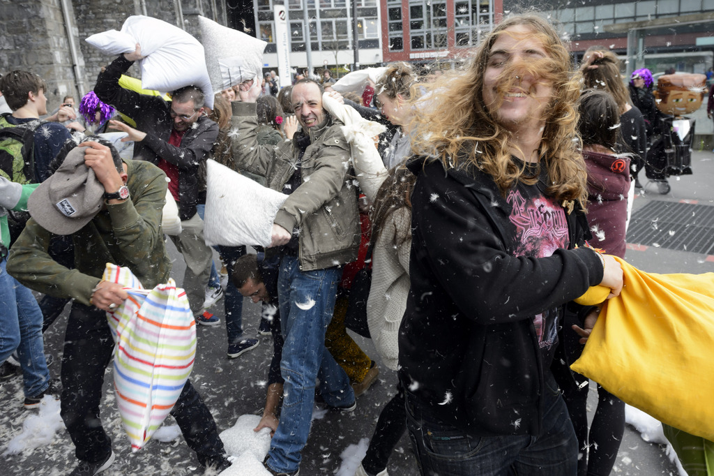 Young people amuse themselves taking part in a pillow fight during the pillow fight day in Lausanne, Switzerland, Saturday, April 5, 2014. Approximately 100 people taking part in Lausanne at this mass pillow fight, a flash mobbing event with internet-based promotion. (KEYSTONE/Laurent Gillieron)