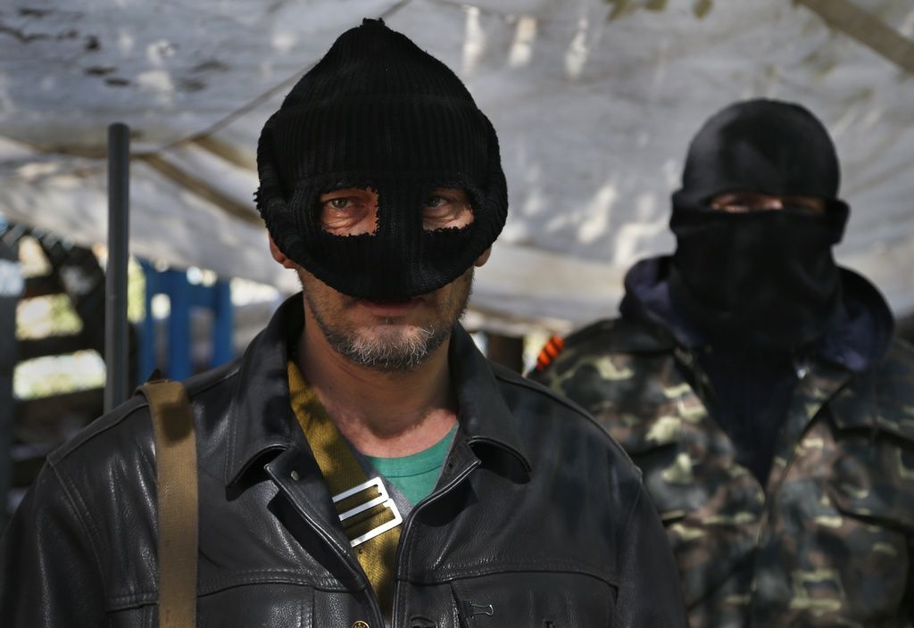 Masked pro Russian militants stand guard at the barricades in Slovyansk , eastern Ukraine, Friday, April 25, 2014. Russian Foreign Minister Sergey Lavrov has accused the West of plotting to control Ukraine and said the pro-Russian insurgents in the southeast would lay down their arms only if the Ukrainian government clears out the Maidan protest camp in the capital Kiev. (AP Photo/Sergei Grits)