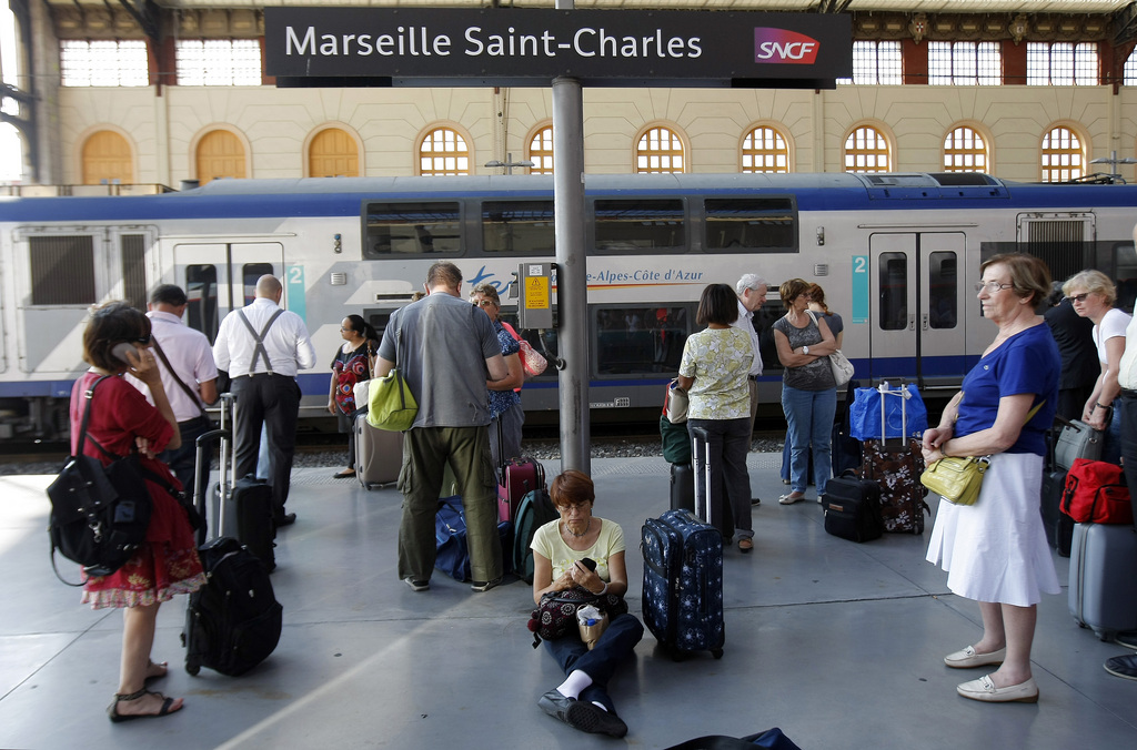 People wait a train on a platform at the Gare St-Charles station in Marseille, southern France , Thursday, June 12, 2014, as French rail workers strike to protest against plans to open the railways to competition. Workers on the French national railway SNCF are striking over plans to streamline and open the state-run network, considered among the world's best, to private competition. (AP Photo/Claude Paris)