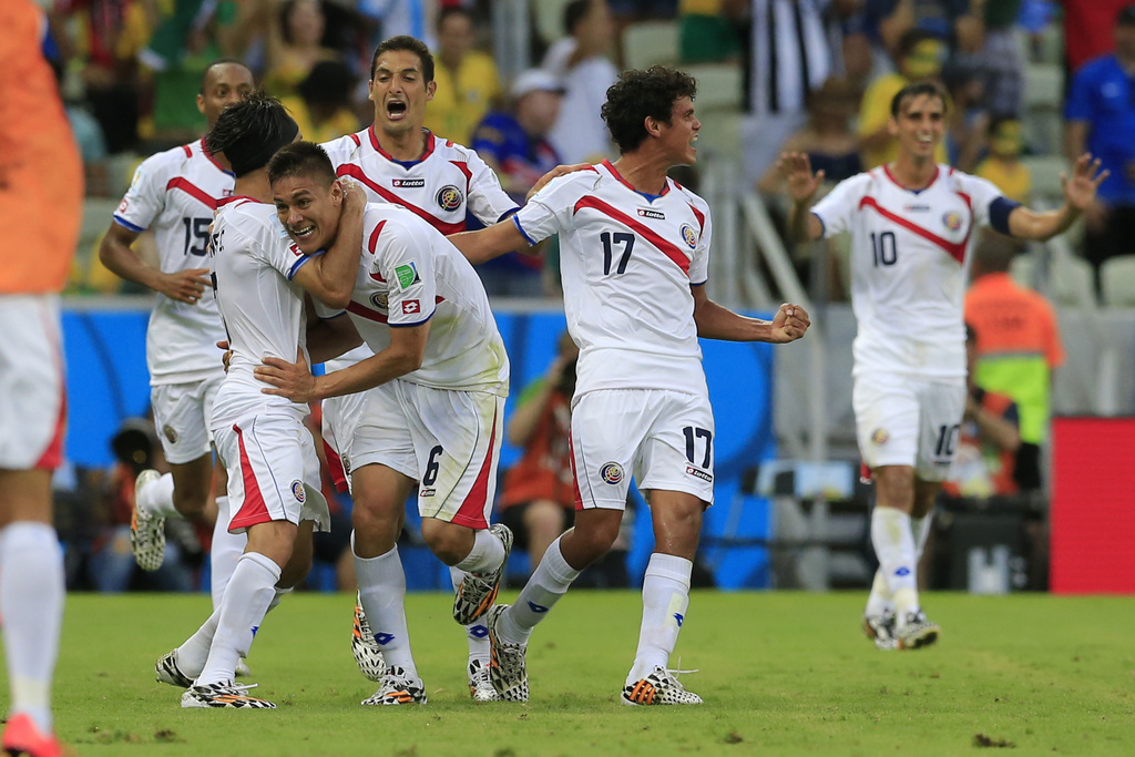Costa Rica's Oscar Duarte, center, celebrates after scoring his side's second goal during the group D World Cup soccer match between Uruguay and Costa Rica at the Arena Castelao in Fortaleza, Brazil, Saturday, June 14, 2014.  (AP Photo/Bernat Armangue)