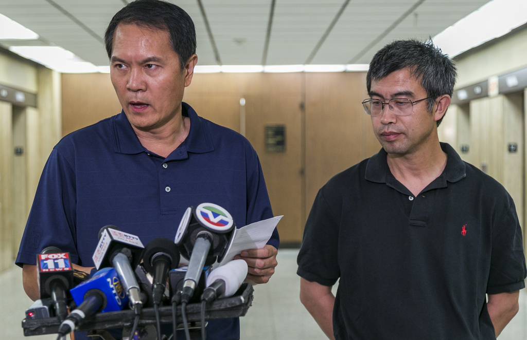 George He, left, and Sean Kong, right, both friends of the father of slain Chinese student Xinran Ji, read a statement from the family on behalf of his parents, as they are still in China unable to get a U.S. travel visa, at Los Angeles Superior Court on Tuesday, July 29, 2014. Four teens are charged with murder in the fatal beating of a University of Southern California graduate student with a baseball bat and wrench as he walked to his off-campus apartment after meeting with a study group. (AP Photo/Damian Dovarganes)