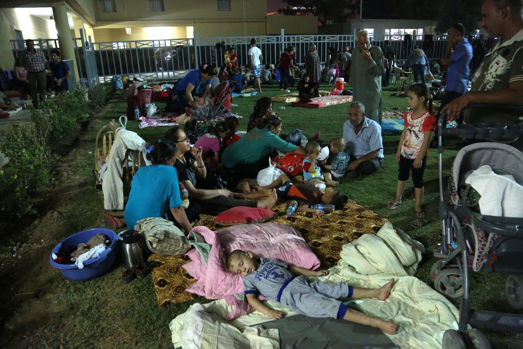 Displaced Iraqi Christians settle at St. Joseph Church in Irbil, northern Iraq, Thursday, Aug. 7, 2014. Late Wednesday, militants overran a cluster of predominantly Christian villages alongside the country's semi-autonomous Kurdish region, sending tens of thousands of civilians and Kurdish fighters fleeing from the area, several priests in northern Iraq said Thursday. (AP Photo/ Khalid Mohammed)