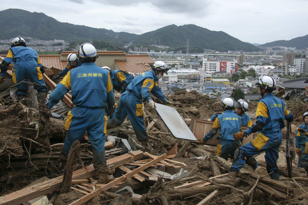 epa04360886 Police rescue workers search for missing people at a landslide site in Hiroshima, Hiroshima Prefecture, western Japan, 20 August 2014. At least 32 people were killed and nine still missing after torrential rain triggered flood and landslides hit in northern area of the city in the early morning 20 August.  EPA/KIMIMASA MAYAMA