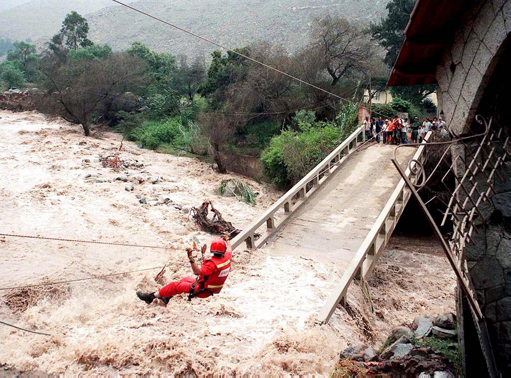 === PERU OUT ===  LIM01-19980316-SANTA EULALIA, PERU: A rescue worker from an emergency crew climbs down a cable rigged to the collapsed Parca bridge over the rushing waters of the Rimac River 14 March 1998 in Santa Eulalia, Peru, while cut-off residents (R) of the small town wait for assistance. Peruvian authorities report that El Nino-related weather has killed over 200 people and caused 190 million USD worth of damage in the past few months.          EPA PHOTO      AFP/EL COMERCIO/ev-oc-sw/kr