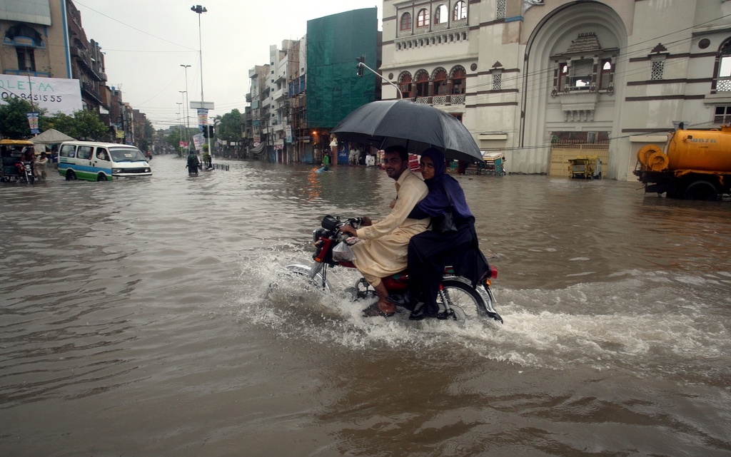 A makes his way through a flooded road caused by heavy rain in Lahore, Pakistan, Thursday, Sept. 4, 2014. Many people have been killed and scores injured in accidents caused by heavy rain in Punjab province, local media reported on Thursday. (AP Photo/K.M. Chaudary)