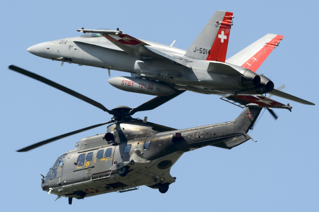An FA-18 jet of the Swiss air force and a helicopter of type Super Puma of the Swiss Army perform at the AIR14 air show in Payerne, Switzerland, Saturday, September 6, 2014. The Air show AIR14 of the Swiss army marks the 100th anniversary of the Air Force also as the 50th anniversary of the Patrouille Suisse and the 25th anniversary of the PC-7 Team. AIR 14 runns during two different weekends, the 30 and 31 August and the 6 and 7 September 2014. (KEYSTONE/Laurent Gillieron)