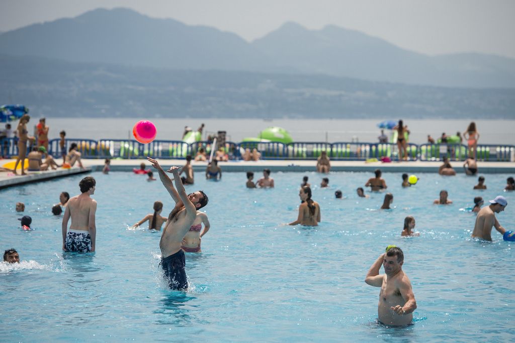 Des baigneurs jouent dans la piscine lors d'une journee de soleil ce samedi 19 juillet 2014 a la piscine de Bellerive a Lausanne. (KEYSTONE/Jean-Christophe Bott)....People enjoy the warm weather in a public bath in Lausanne, Switzerland, 19 Juy 2014. (KEYSTONE/Jean-Christophe Bott)