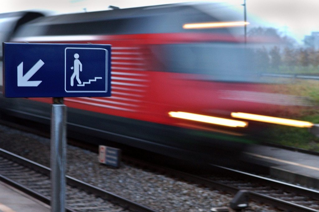 Un train des Chemins de Fer Federaux Suisses, CFF, passe derriere un panneau qui indique le passage sous voie de la gare de Gilly-Bursinel, qui sera totalement fermee des le 12 decembre prochain, ce mardi 7 decembre 2004 a Bursinel, Vaud. Le 12 decembre 2004 figurera dans les livres d'histoire comme une des plus grandes journees des CFF. Elle correspond au lancement de Rail 2000 avec le plus important changement d'horaire et egalement de nombreuses fermeture de gare regionale. (KEYSTONE/Laurent Gillieron)