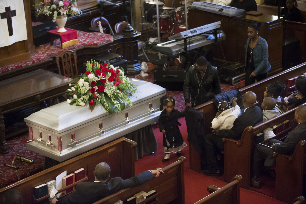 Mourners attend the funeral for Akai Gurley at Brown Baptist Memorial Church, Saturday, Dec. 6, 2014, in the Brooklyn borough of New York. Gurley was shot to death by rookie NYPD officer Peter Liang in a pitch black hallway of the Louis Pink Houses public housing complex in November. Police have described Gurley's death as an apparent accident. (AP Photo/John Minchillo)