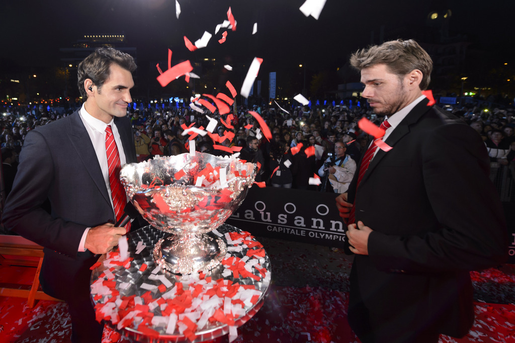 Swiss Davis Cup Team captain tennis players Stanislas "Stan" Wawrinka, right, and Roger Federer, left, celebrate with their fans, one day after winning the Davis Cup Final against France, during a public welcoming ceremony in Lausanne, Switzerland, Monday, November 24, 2014. (KEYSTONE/Laurent Gillieron)