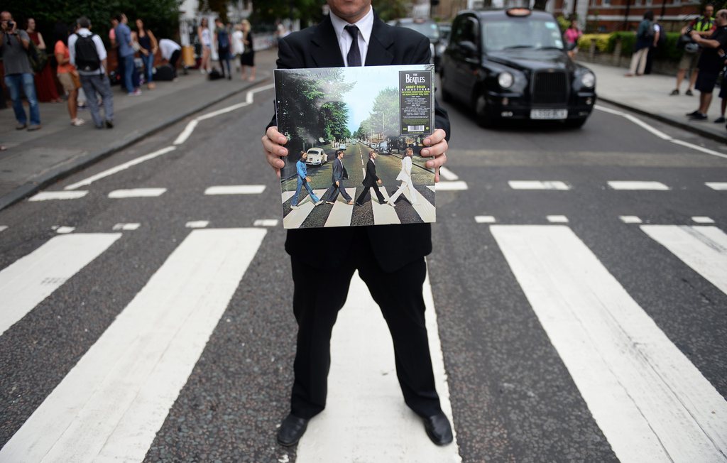 epa04345574 British actor Andrew Lancel who plays Brian Epstein in the London stage show 'Epstein' holds the album of Abbey Road at Abbey road in London, Britain, 08 August  2014. Hundreds of Beatles fans turned out to celebrate the 45th anniversary of Abbey Road.  EPA/ANDY RAIN
