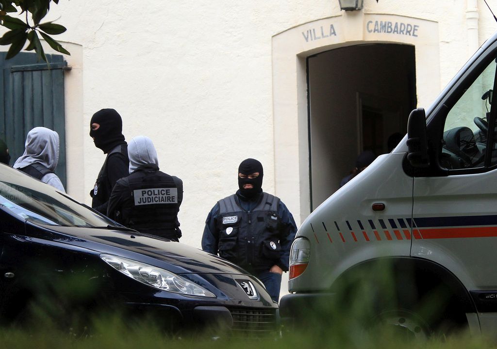 French police officers stand outside a villa during a search operation for what could be a major stash or arms in Biarritz, southwestern France, Thursday, May 28, 2015. French and Spanish authorities have detained one person and are raiding a villa in the French Atlantic coast city of Biarritz, in an operation targeting the Basque separatist group ETA. (AP Photo/Bob Edme)