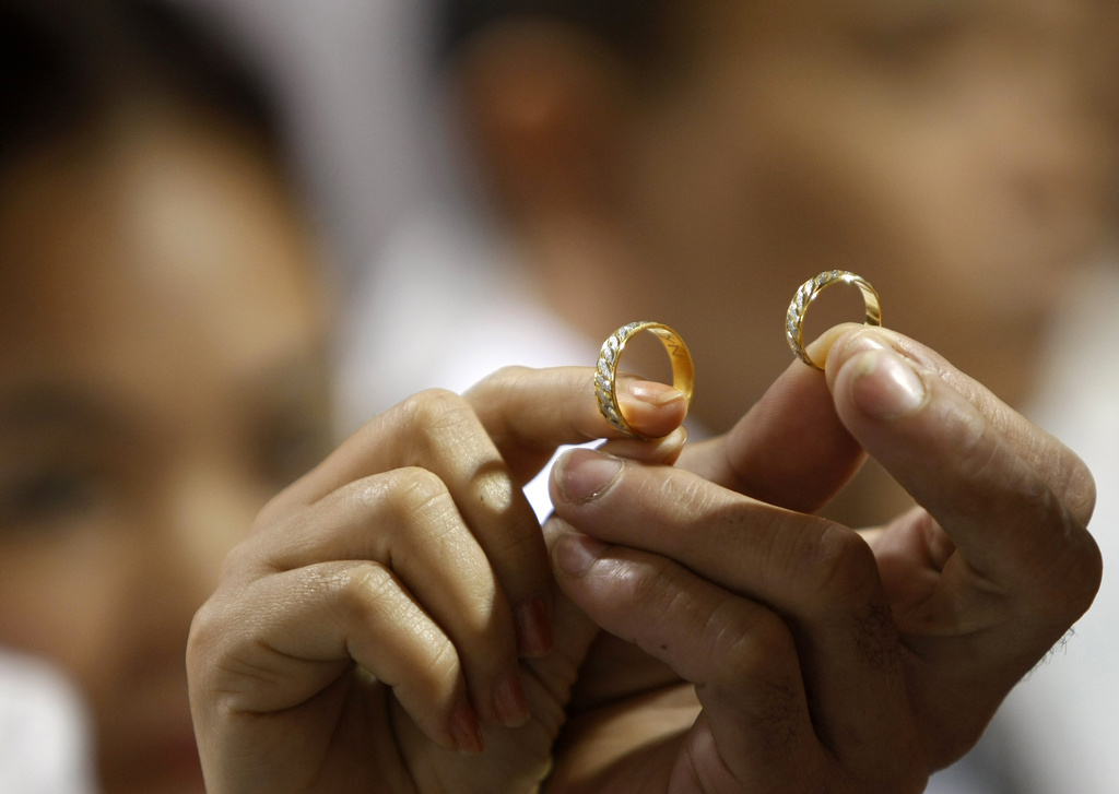 A couple displays their wedding rings during a mass wedding sponsored by the city of Paranaque, south of Manila, Philippines on Valentine's Day Tuesday, Feb. 14, 2012. More than 300 couples, all residents of the city, tied the knot Tuesday that becomes the annual tradition of the city on Valentine's Day. (AP Photo/Bullit Marquez) === STAND ALONE === 