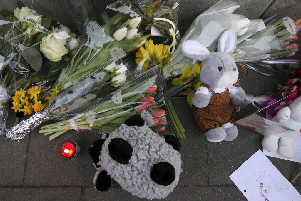 Flowers and tributes are placed outside the Sint Lambertus school in Heverlee, Belgium, to commemorate the pupils of the school involved in a bus crash in Switzerland, Wednesday, March 14, 2012. A tour bus slammed into a tunnel wall in the Swiss Alps on Wednesday morning in a horrific accident that killed 22 Belgian 12-year-old students returning from a joyous ski vacation as well as the six adults who were accompanying them. (AP Photo/Yves Logghe)