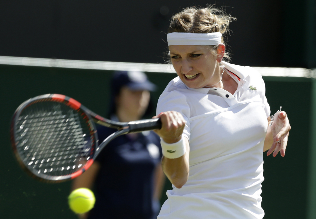 Timea Bacsinszky of Switzerland returns a ball to Sabine Lisicki of Germany during their singles match at the All England Lawn Tennis Championships in Wimbledon, London, Saturday July 4, 2015. (AP Photo/Alastair Grant)