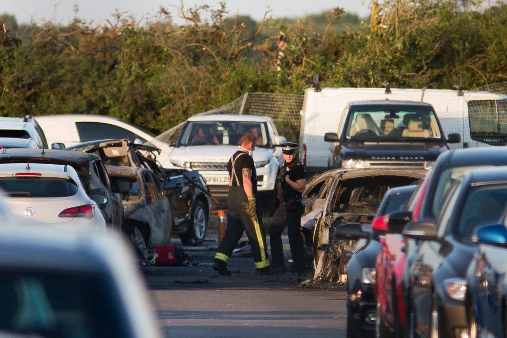epa04868262 Emergency services inspect the crash site at Blackbushe Airport in Hampshire, after four people died when a private Phenom 300 jet crash-landed in a car auction site and burst into flames as it approached the runway in Farnborough, Britain, 31 July 2015. The Saudi General Authority of Civil Aviation has confirmed that the plane was a Saudi-registered jet.  EPA/DANIEL LEAL-OLIVAS UK AND IRELAND OUT  EDITORIAL USE ONLY
