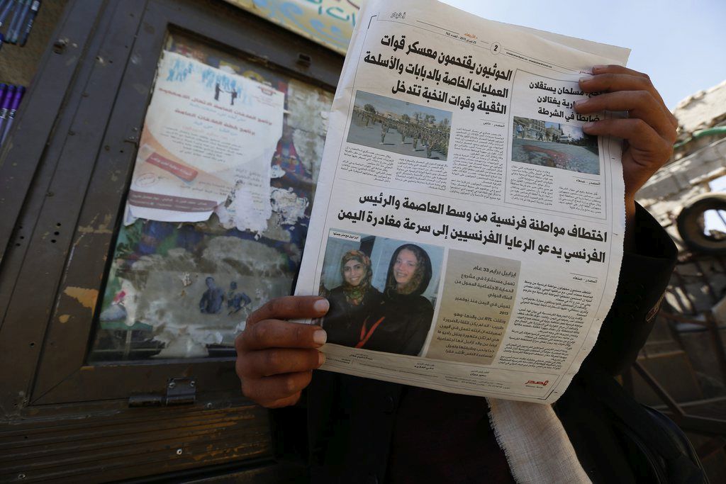 epa04636314 A Yemeni man reads a local newspaper publishing a photograph of kidnapped French development worker Isabelle Prime (R) and her Yemeni aide Shireen Makkauy (L), a day after they were kidnapped by gunmen in Sana?a, Yemen, 25 February 2015. French authorities said a French woman working for the World Bank was kidnapped on 24 February in the Yemeni capital. No one took immediate responsibility for the kidnapping.  EPA/YAHYA ARHAB