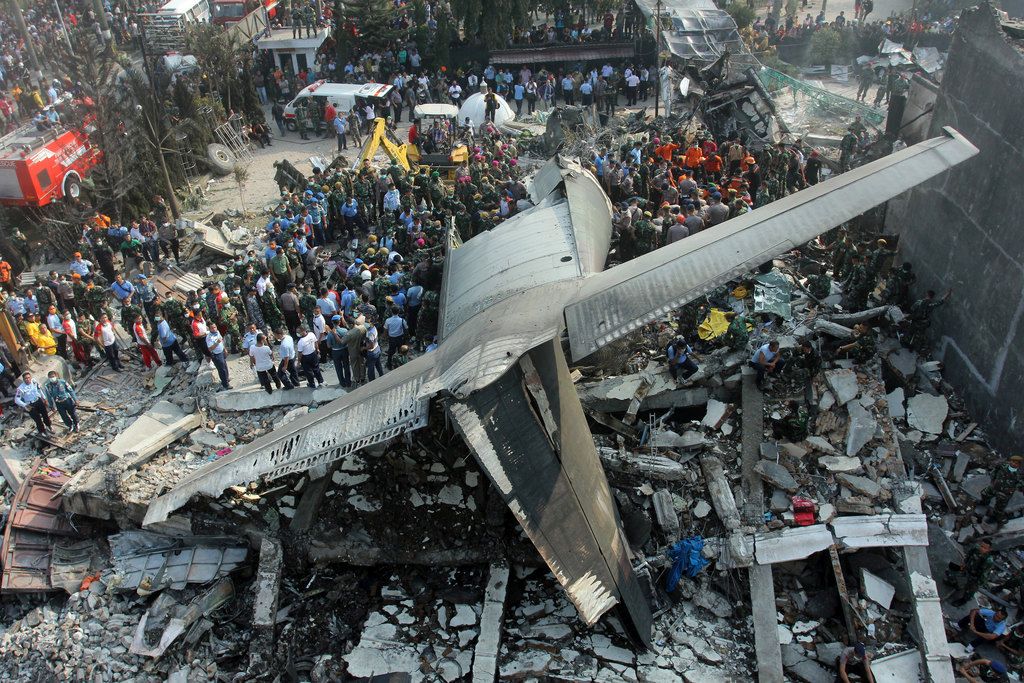 Rescuers search for victims at the site where an air force cargo plane crashed in Medan, North Sumatra, Indonesia, Tuesday, June 30, 2015. The Hercules C-130 plane crashed into a residential neighborhood in the country's third-largest city Medan. (AP Photo/Yudha Lesmana)