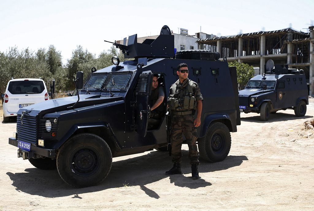 Security members outside a building after two police officers were found shot dead in their home in Ceylanpinar, a town near Turkey?s border with Syria, Wednesday, July 22, 2015. Governor for Sanliurfa province, Izzettin Kucuk, says Wednesday it was not immediately clear if the attack against the policemen who were sharing a house, was terrorism-linked.  (AP Photo/Emrah Gurel)