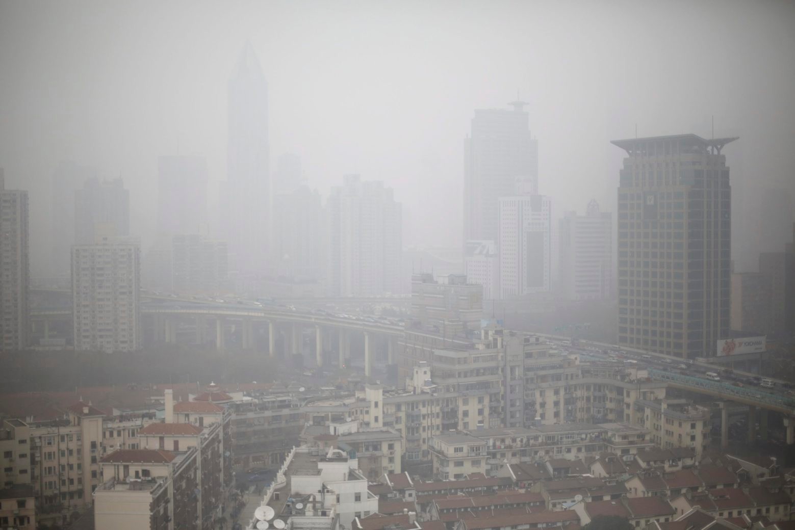 ZUM KLIMAGIPFEL IN PARIS VOM 30. NOVEMBER BIS ZUM 11. DEZEMBER 2015  STELLEN WIR IHNEN FOLGENDES BILDMATERIAL ZUR VERFUEGUNG - Houses and buildings are seen on a heavy haze in Shanghai, China, on Thursday, Jan. 24, 2013. Air pollution is a major problem in China due to the country's rapid pace of industrialization, reliance on coal power, explosive growth in vehicle ownership and disregard for environmental laws, with development often taking priority over health. The pollution typically gets worse in the winter because of an increase in coal burning. (KEYSTONE/AP/Eugene Hoshiko) UN KLIMAKONFERENZ
