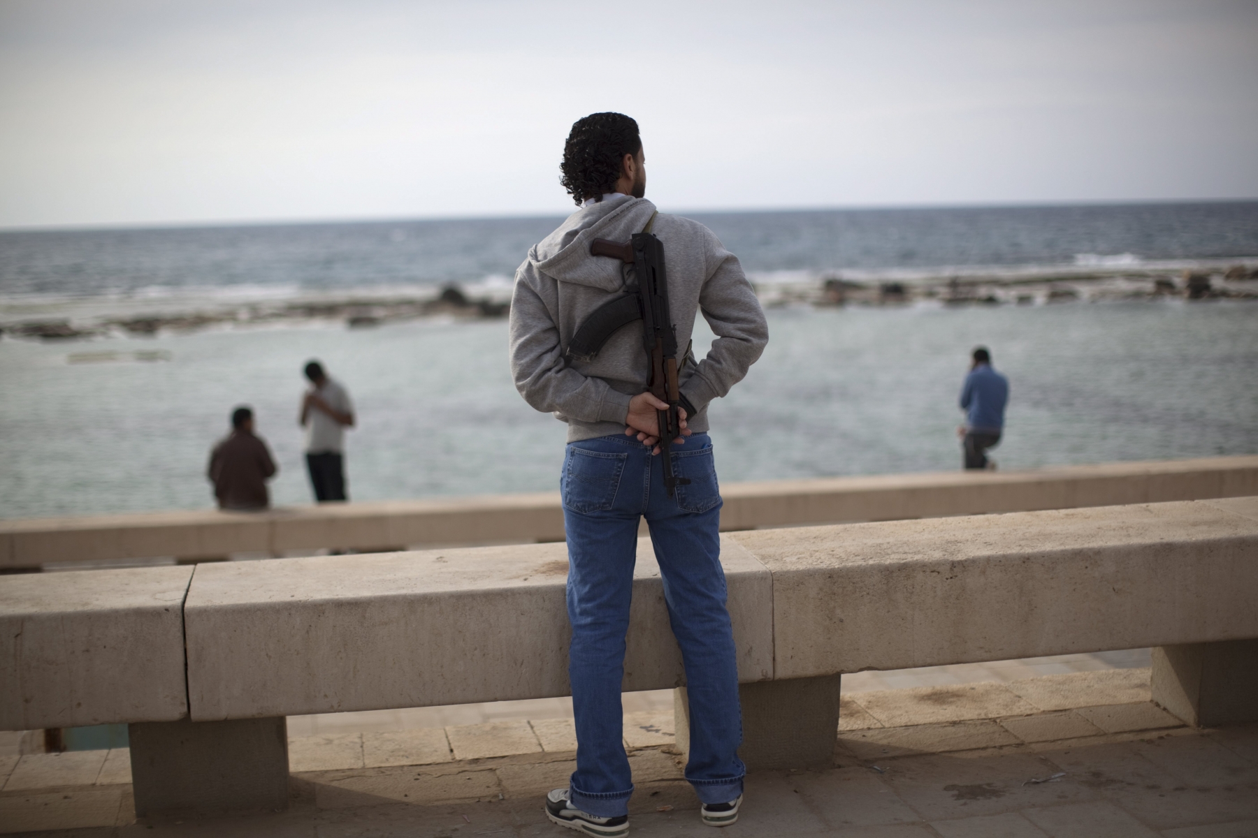 A rebel fighter looks out to the Mediterranean Sea from the seaside in Benghazi, Libya, Sunday, May 8, 2011.  (AP Photo/Rodrigo Abd)