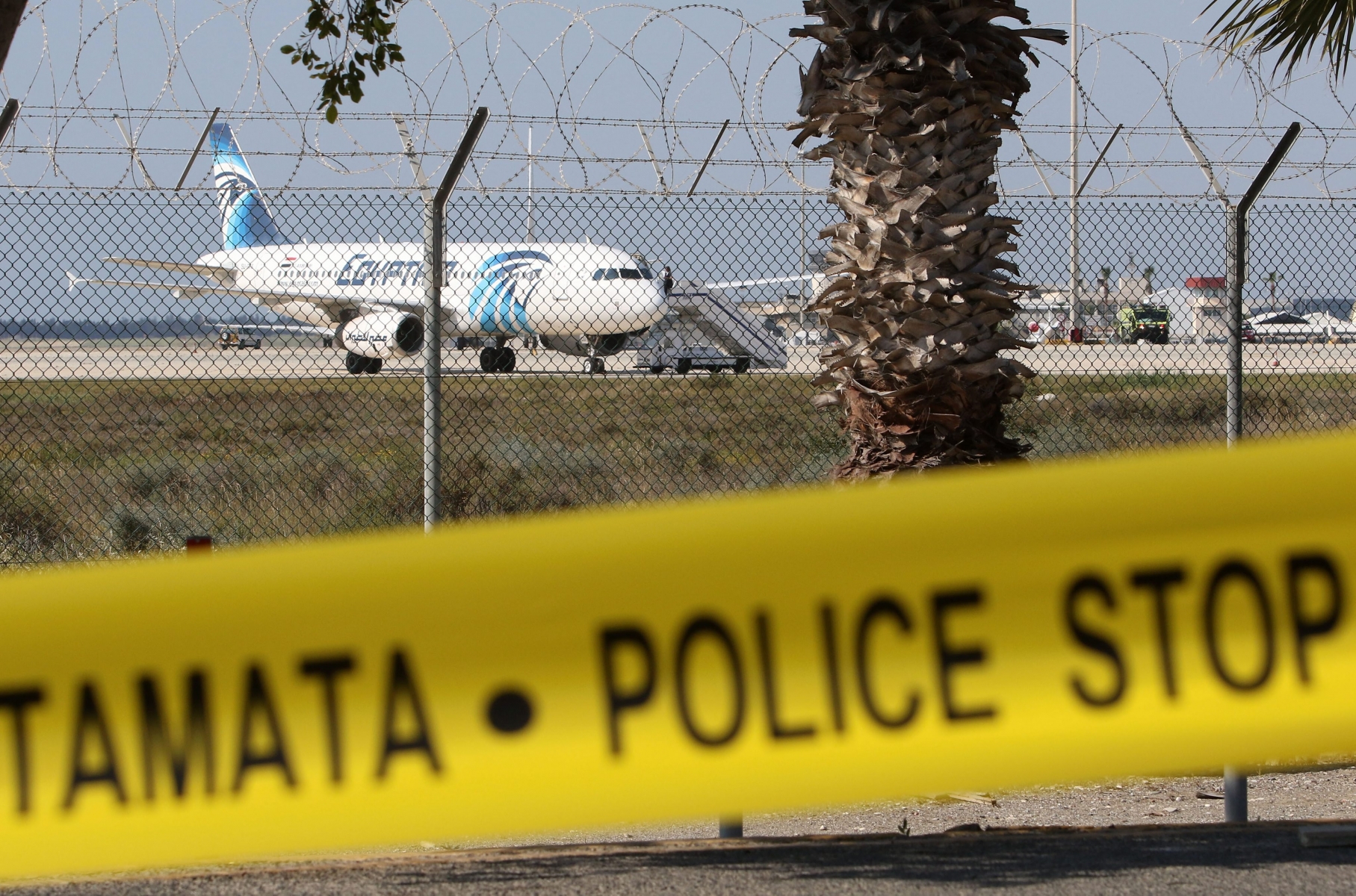 epa05234318 Police barrier tape seals off the area where a hijacked EgyptAir A320 plane was parked at Larnaca Airport, in Larnaca, Cyprus, 29 March 2016. The passenger plane from the Egyptian airline 'EgyptAir' was hijacked earlier the same morning, after being forced to divert its route from Alexandria to Cairo. The plane was carrying 81 passengers when it landed on Larnaca airport in Cyprus.  EPA/KATIA CHRISTODOULOU