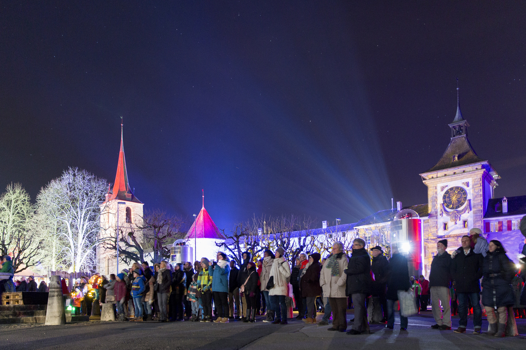 Des gens regardent les bâtiments illuminés de la ville de Morat lors du premier jour du Festival des Lumières, en janvier.