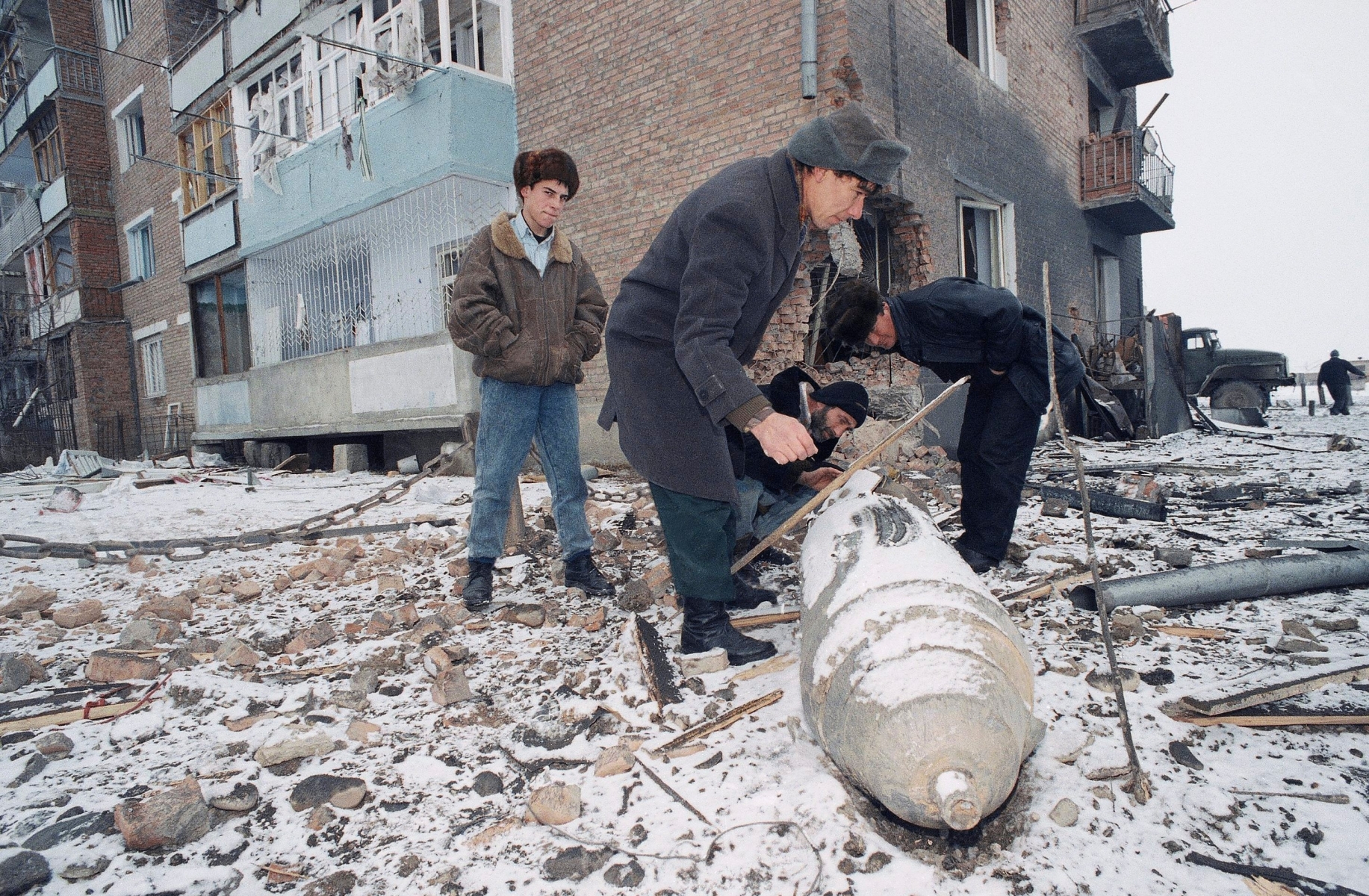 Chechen men look at an un-exploded Russian bomb near their house in Argun, 9 miles (15 km) East of Grozny, in the break-away republic of Chechnya, after the latest air-raid by Russian forces, Saturday, Dec. 24, 1994 in Russia. (AP Photo/Alexander Zemlianichenko) RUSSLAND TSCHETSCHENIEN KRIEG 1994