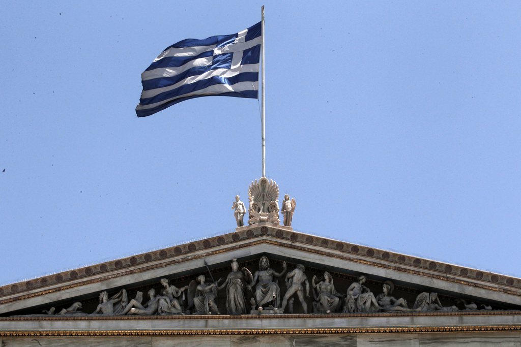 The Greek flag flies over Athens Academy in Athens on Tuesday June 5, 2012. Greece is in a fifth year of recession, with poverty and unemployment rapidly rising amid protracted harsh cutbacks implemented to secure vital international bailout loans. But political uncertainty ahead of new elections on June 17 has intensified fears that the country could be forced to abandon the euro and revert to a devalued version of its old drachma currency. (AP Photo/Dimitri Messinis)