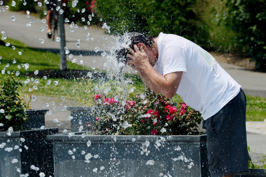 epa03288776 A man sticks his head in a fountain to cool off during a blistering heat wave in Washington DC, USA, 29 June 2012. The temperature rose to 102 Fahrenheit (38.88 Celsius) in Washington, which broke a 138-year-old record for 29 June. The heat index, including humidity, made it feel closer to 110 F, according to the National Weather Service.  EPA/MICHAEL REYNOLDS